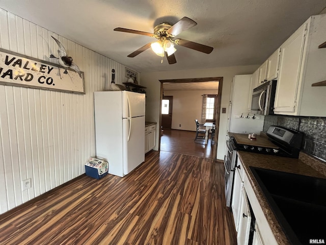 kitchen with sink, dark wood-type flooring, white refrigerator, range with electric stovetop, and white cabinets