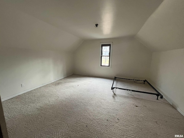 additional living space with light carpet and vaulted ceiling