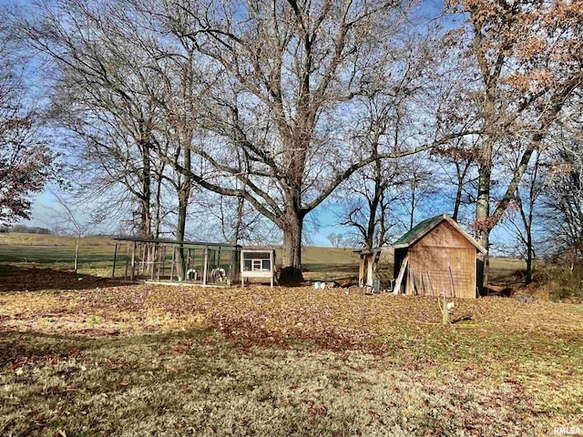 view of yard with a rural view and an outbuilding