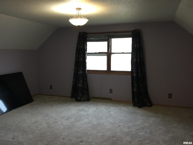 bonus room with vaulted ceiling and carpet floors