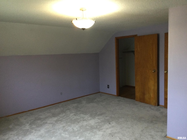 additional living space featuring lofted ceiling and carpet flooring