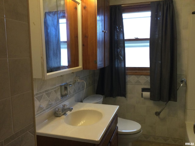 bathroom featuring tile walls, vanity, plenty of natural light, and toilet