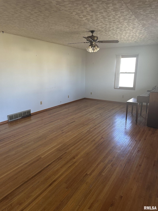 spare room with ceiling fan, a textured ceiling, and dark hardwood / wood-style flooring