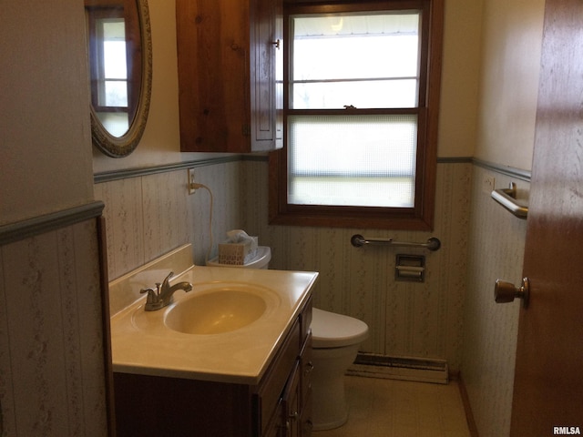 bathroom featuring vanity, toilet, and baseboard heating