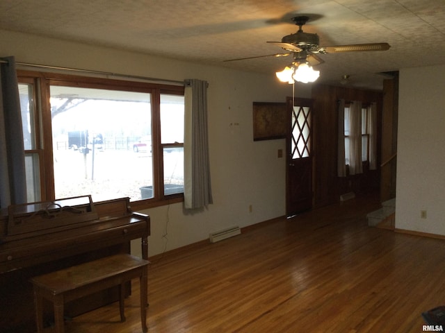 miscellaneous room featuring a baseboard radiator, dark hardwood / wood-style floors, and ceiling fan