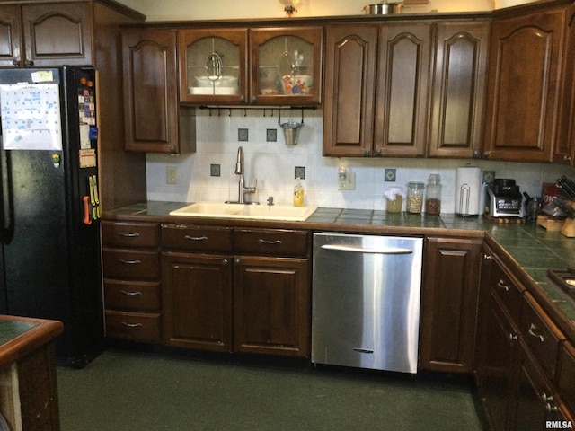 kitchen with dark brown cabinetry, dishwasher, black refrigerator, and sink