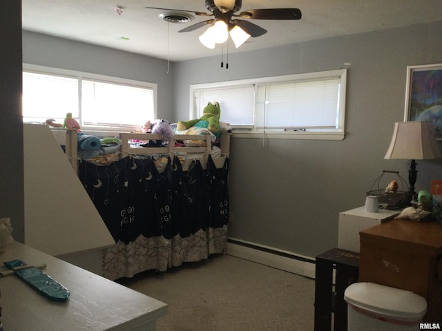 bedroom with ceiling fan and a baseboard heating unit