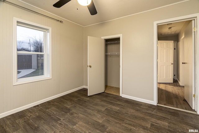 unfurnished bedroom with dark hardwood / wood-style flooring, ceiling fan, a closet, lofted ceiling, and wood walls