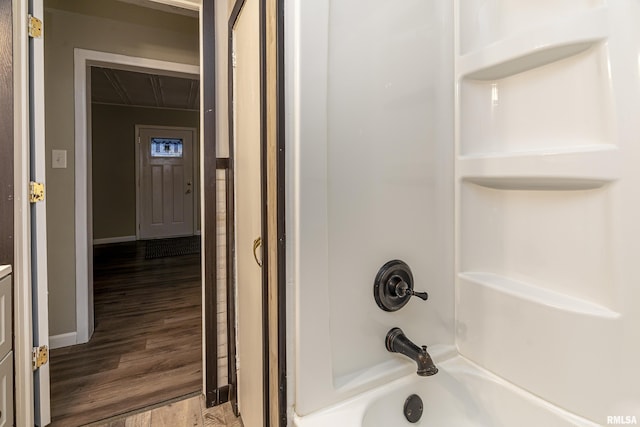 bathroom with shower / bathing tub combination and wood-type flooring