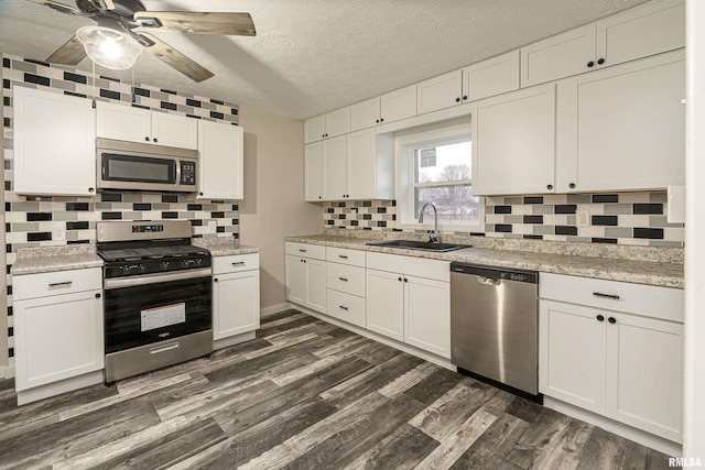 kitchen with backsplash, white cabinets, sink, dark hardwood / wood-style floors, and appliances with stainless steel finishes