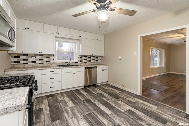 kitchen featuring dark hardwood / wood-style flooring, white cabinetry, backsplash, and appliances with stainless steel finishes