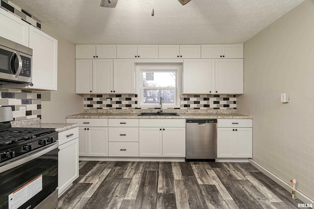 kitchen featuring white cabinetry, sink, dark hardwood / wood-style floors, and appliances with stainless steel finishes