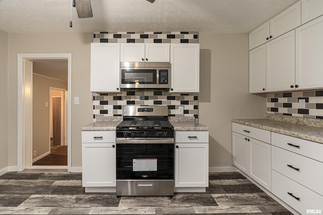 kitchen featuring white cabinets, appliances with stainless steel finishes, a textured ceiling, and dark hardwood / wood-style floors