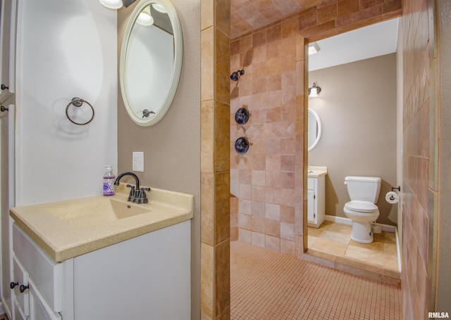 bathroom featuring tile patterned flooring, vanity, toilet, and tiled shower