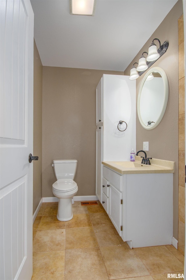 bathroom with tile patterned flooring, vanity, and toilet