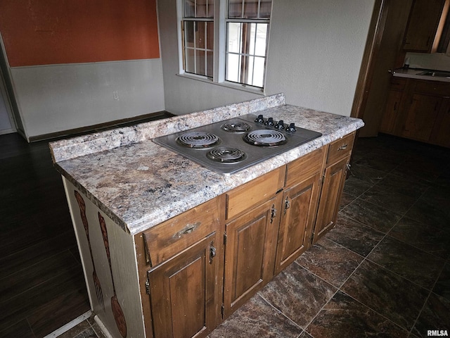 kitchen with black electric cooktop and light stone counters