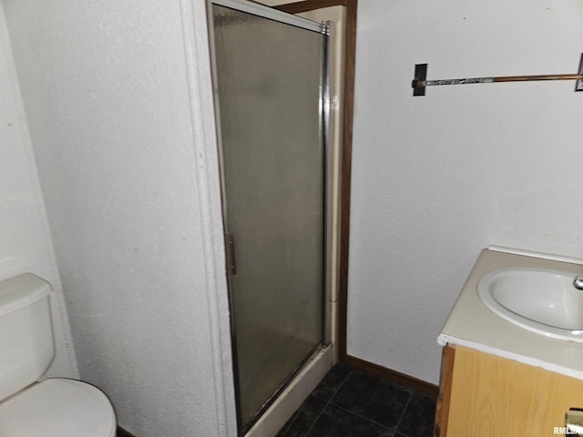 bathroom featuring tile patterned flooring, vanity, toilet, and walk in shower