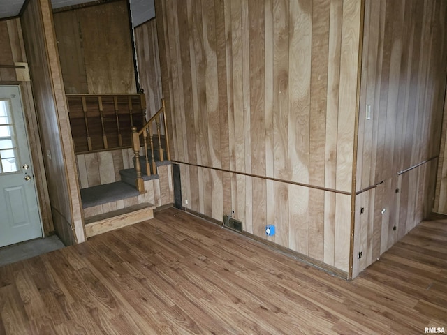 interior space with hardwood / wood-style floors and wood walls