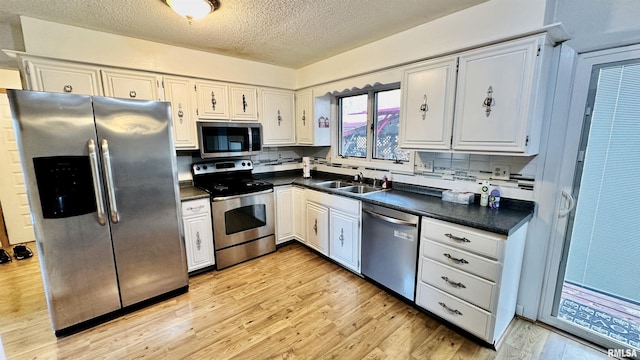 1807 E Saint Louis St, West Frankfort, IL 62896 - kitchen with stainless steel appliances, dark countertops, a textured ceiling, and decorative backsplash