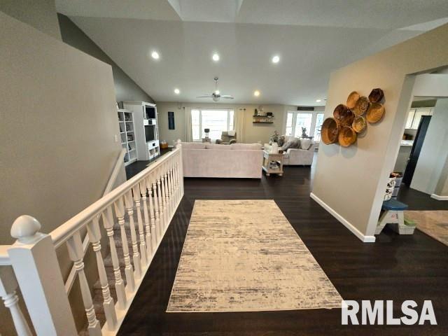 hallway featuring dark hardwood / wood-style floors and lofted ceiling