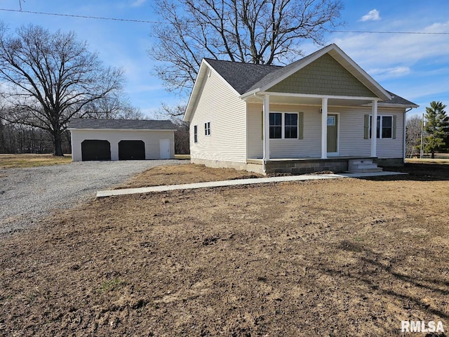 view of front of house featuring an outbuilding, a porch, and a detached garage