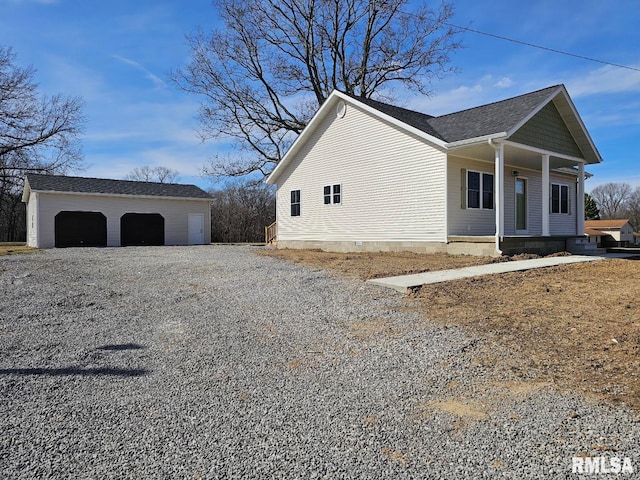 view of property exterior featuring an outbuilding, covered porch, and a detached garage