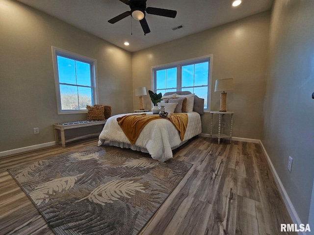 bedroom with visible vents, baseboards, and wood finished floors