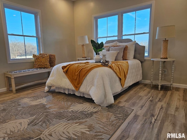 bedroom with baseboards and wood finished floors