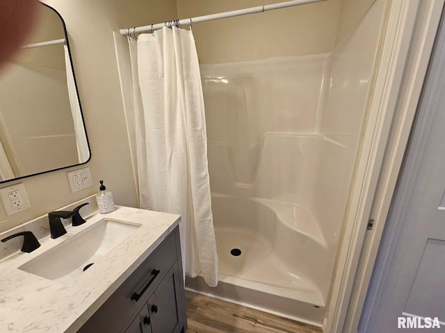 bathroom featuring curtained shower, wood finished floors, and vanity