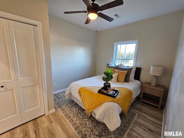 bedroom featuring visible vents, light wood-style flooring, a ceiling fan, and baseboards