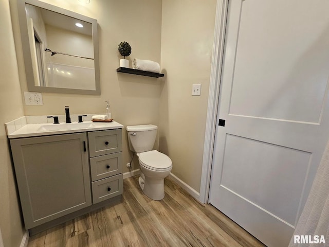 full bathroom with vanity, toilet, wood finished floors, and baseboards