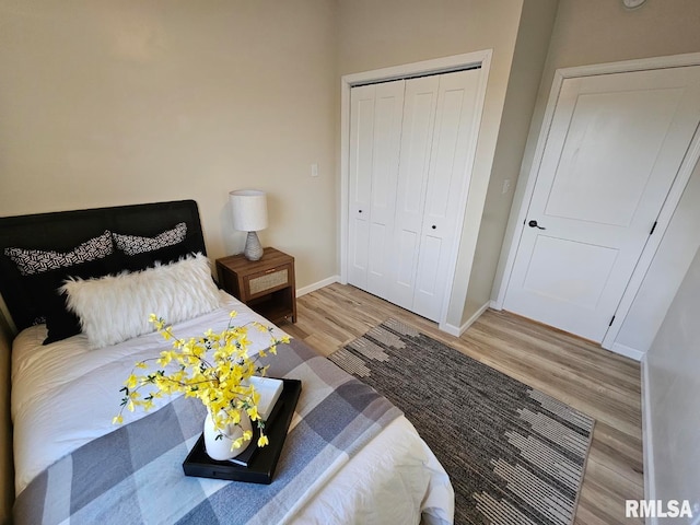 bedroom featuring a closet, baseboards, and wood finished floors