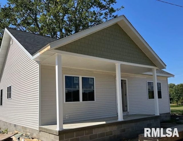 view of front of property featuring a porch and a shingled roof