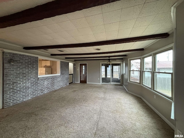 unfurnished living room featuring ceiling fan, carpet, a healthy amount of sunlight, and brick wall