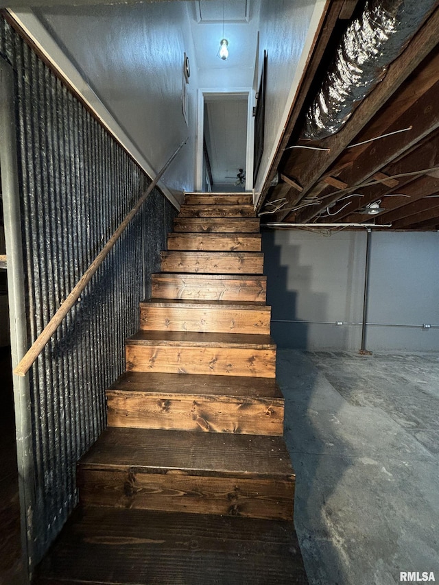 staircase featuring concrete floors