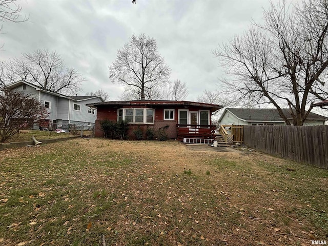 back of house featuring a yard and a wooden deck