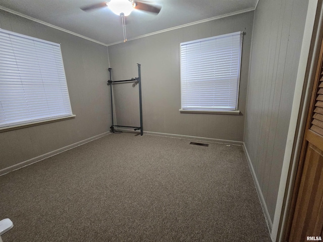 carpeted empty room featuring ceiling fan and crown molding