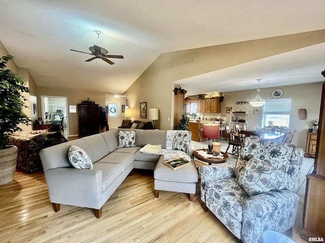 living room with ceiling fan, light wood-type flooring, and lofted ceiling