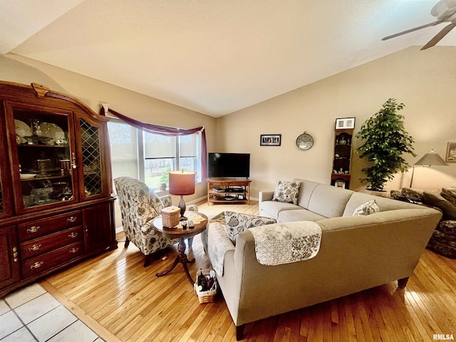 living room with light hardwood / wood-style floors, ceiling fan, and lofted ceiling