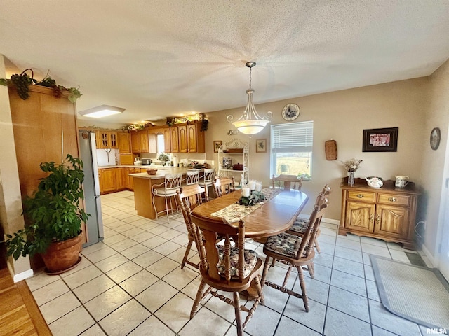 tiled dining room with a textured ceiling