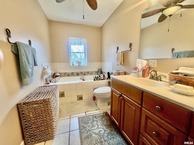 bathroom featuring vanity, tile patterned floors, ceiling fan, toilet, and tiled bath