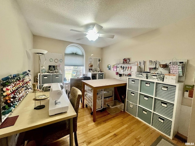 home office featuring ceiling fan, a textured ceiling, and light hardwood / wood-style flooring