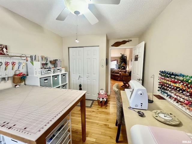 kitchen featuring ceiling fan, wood-type flooring, and a textured ceiling