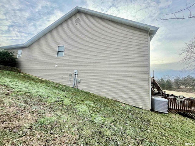 view of side of home with a lawn and a wooden deck