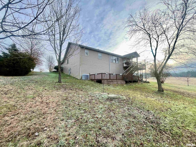 back of property with central air condition unit, a lawn, and a wooden deck