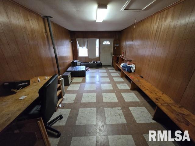 unfurnished office featuring wood walls