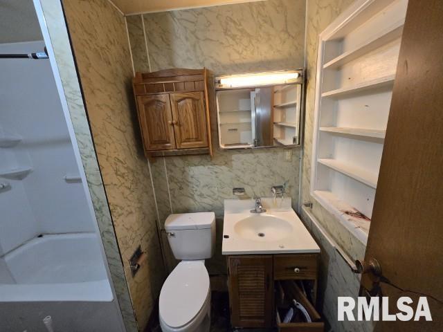 bathroom with toilet, vanity, and built in features