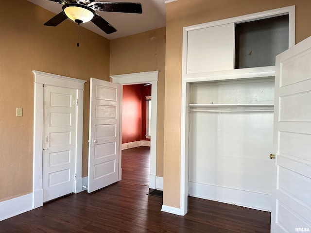 unfurnished bedroom featuring ceiling fan, a closet, dark wood finished floors, and baseboards