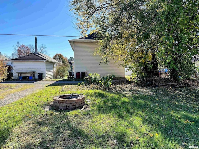 view of property exterior featuring a fire pit and a yard