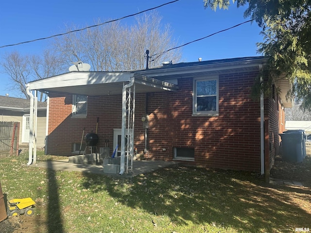 rear view of property featuring a lawn and a patio area